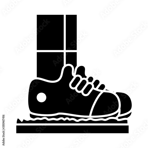 man standing on disinfection mat to clean shoe, silhouette style