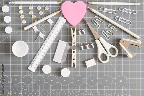 White office tools and pink notepad on grey background photo