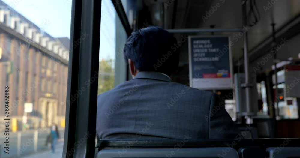 Interior and selected focus view at the back of male passenger with face protection mask who sit in light rail tram or train in Germany during epidemic of COVID-19 virus with new normal concept. Interior and selected focus view at the back of male passenger with face protection mask who sit in light rail tram or train in Germany during epidemic of COVID-19 virus with new normal concept.