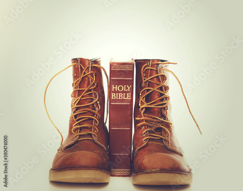 Bible and boots on gray background photo