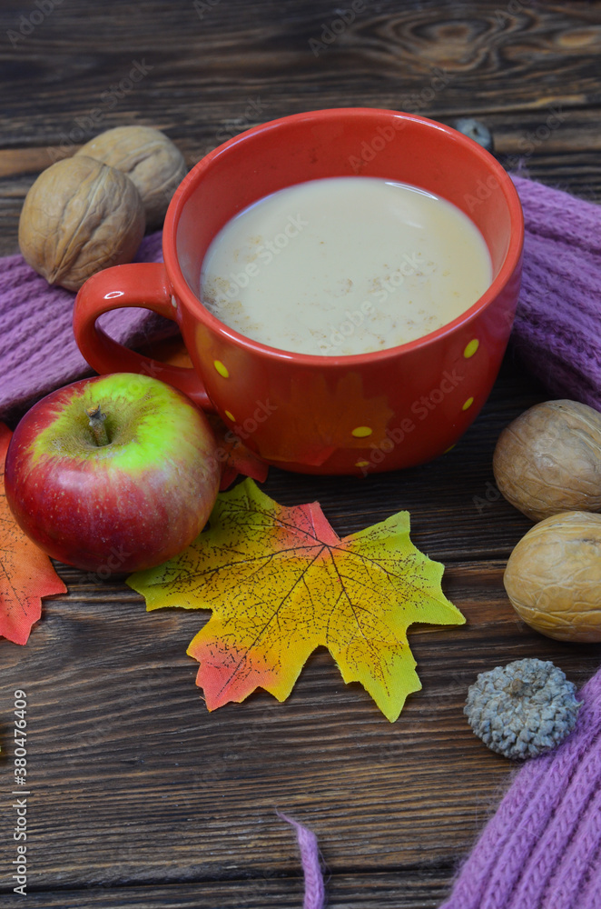 Warming cocoa in cold season, scarf, apples, autumn leaves, nuts. Concept decoration and celebration thanksgiving day Warming cocoa in cold season, scarf, apples, autumn leaves, nuts. Concept decoration and celebration thanksgiving day