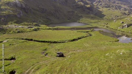 ATV All Terrain Vehicle Driving Over Rugged Land Towards A Remote Lake photo