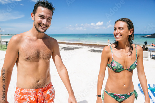 Happy young couple of man and woman in a tropical beach photo