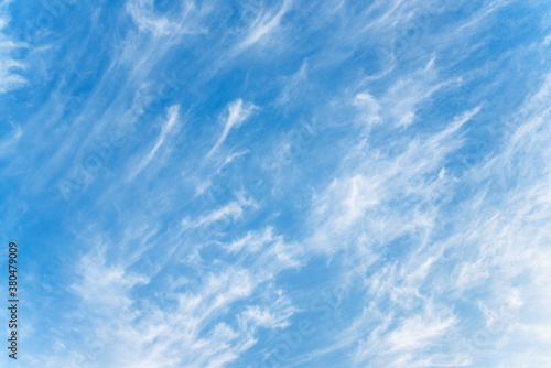 Blue sky and white cirrus clouds background. Amazing spindrift clouds. Natural backdrop.