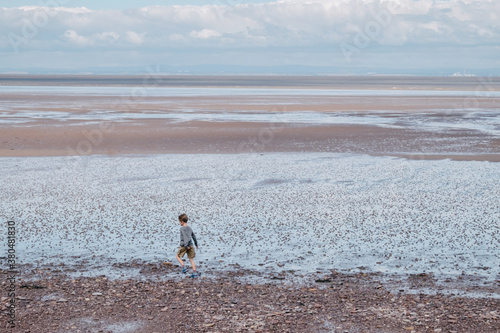 Child runs alnong the mud flats of north Somerset photo