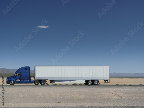 truck driving through desert on the highway photo