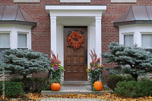 Front door with colorful fall wreath and pumpkins