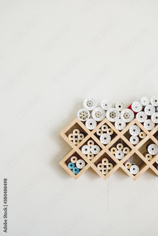 Spools of thread stacked on a grid-based organizer Spools of thread stacked on a grid-based organizer