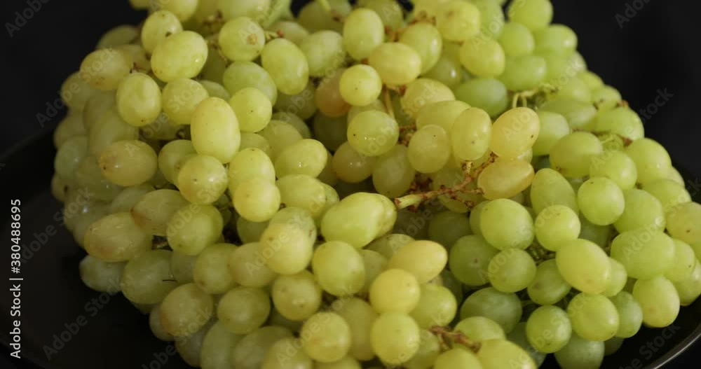 Bunch of white ripe grapes rotating on black background Bunch of white ripe grapes rotating on black background