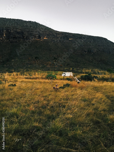 Old-Fashioned White Camper Van Parked in Wild Grassland