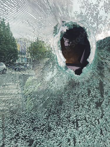 Hole in broken shattered glass window