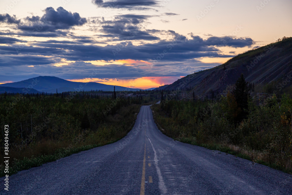 Naklejka premium Scenic Road View of Klondike Hwy during a sunny and colorful sunset. Taken North of Whitehorse, Yukon, Canada.