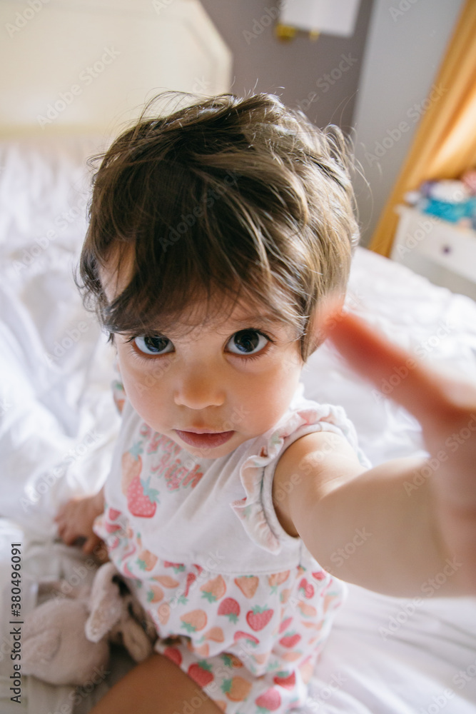 Selfconfident baby girl making a selfie on a bed Selfconfident baby girl making a selfie on a bed