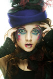 Beautiful woman in hat with artistic make-up.