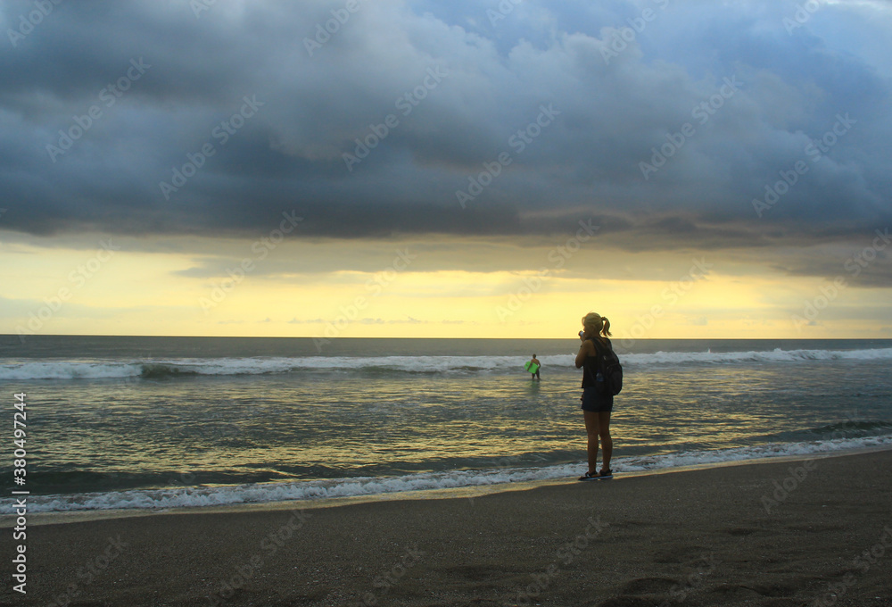 A woman take a photo at Petitenget beach Bali Indonesia
