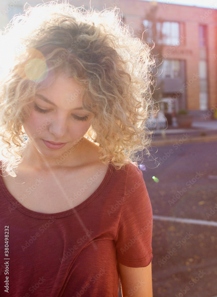 close up of young blonde woman backlit by sun close up of young blonde woman backlit by sun