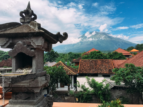 A sculpture between roofs and with a volcano at the background photo
