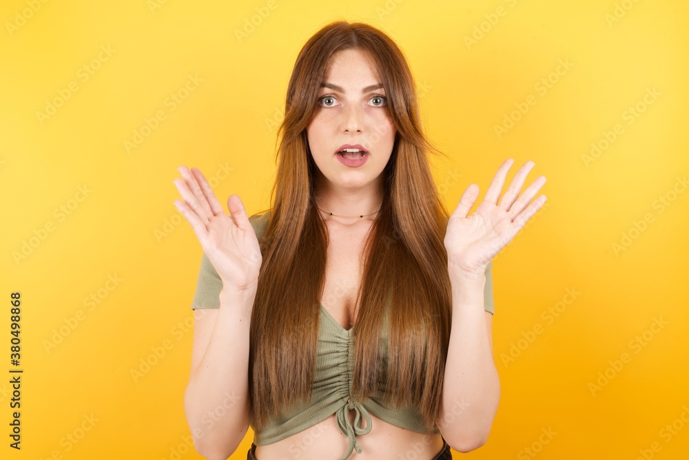 Surprised terrified female isolated over white background. Gestures with uncertainty, stares at camera, puzzled as doesn't know answer on tricky question, People, body language, emotions concept Surprised terrified female isolated over white background. Gestures with uncertainty, stares at camera, puzzled as doesn't know answer on tricky question, People, body language, emotions concept