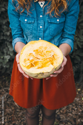 Woman holding half of pumpkin photo