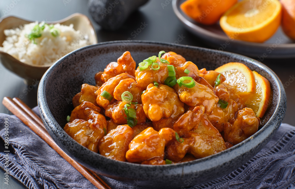 bowl of chinese orange chicken on table top bowl of chinese orange chicken on table top