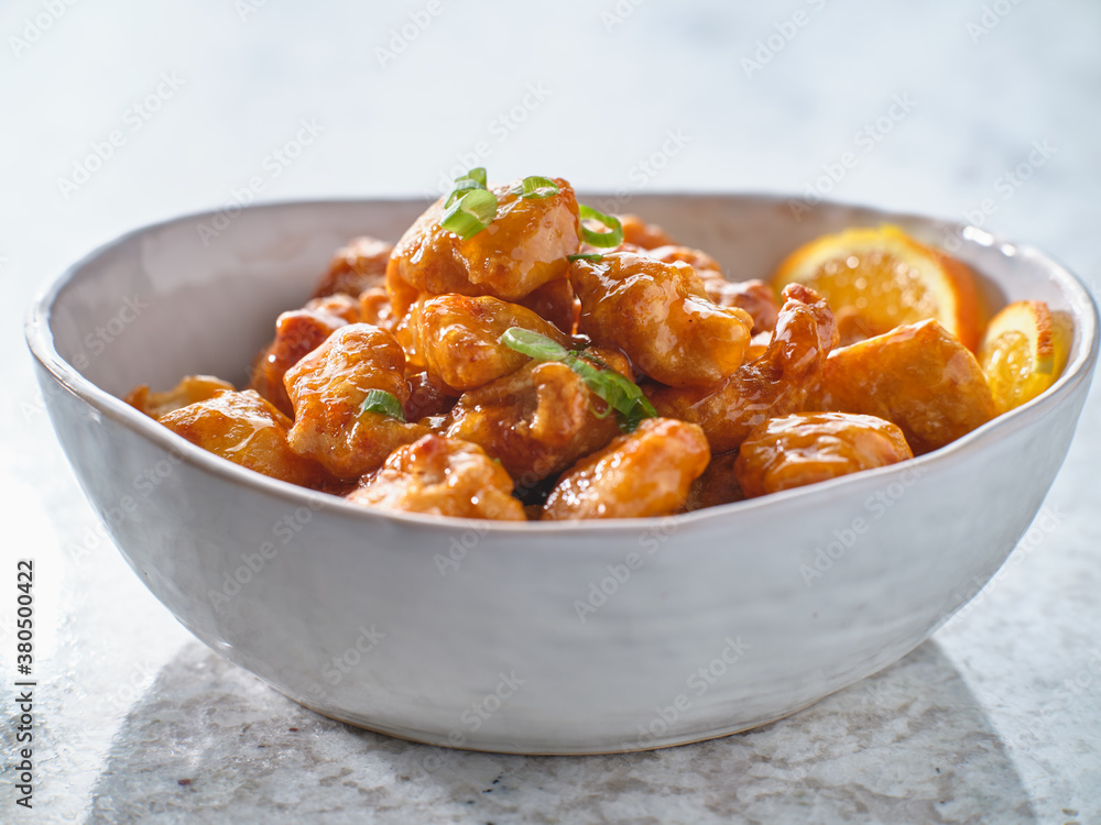 bowl of chinese orange chicken on table top bowl of chinese orange chicken on table top