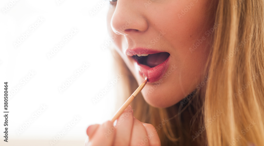 Beautiful model applying lipstick Beautiful model applying lipstick