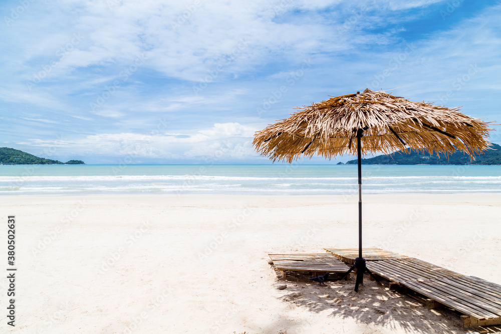 Fototapeta premium Beach Umbrella made of palm leafs on a perfect white beach in front of Sea.