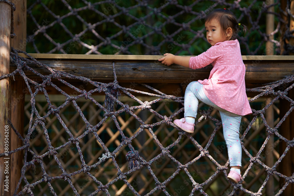 one little asian girl climbing up the net one little asian girl climbing up the net