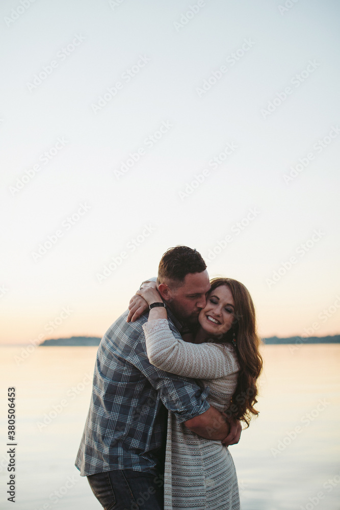 Happy couple enjoying hug together at sunset Happy couple enjoying hug together at sunset