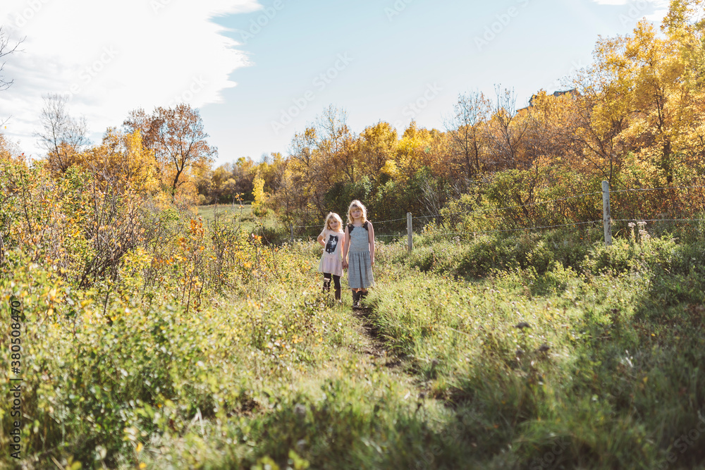Sisters playing in field of trees Sisters playing in field of trees