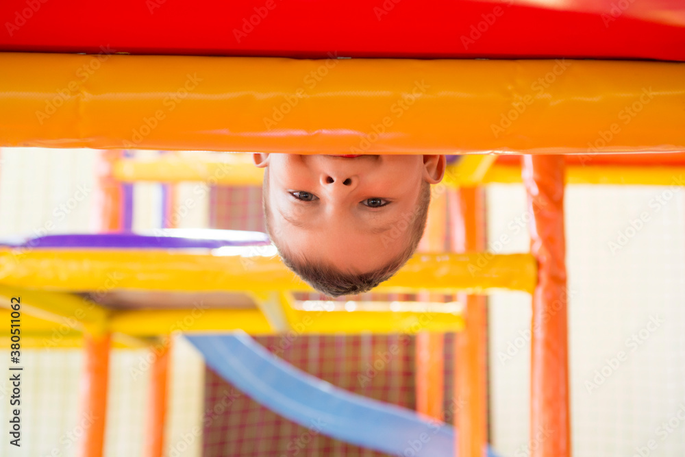 Happy child is playing at a playground. Young caucasian child is playing on the playground Happy child is playing at a playground. Young caucasian child is playing on the playground