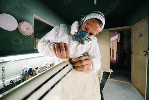 Shaper fixing ding on surfboard