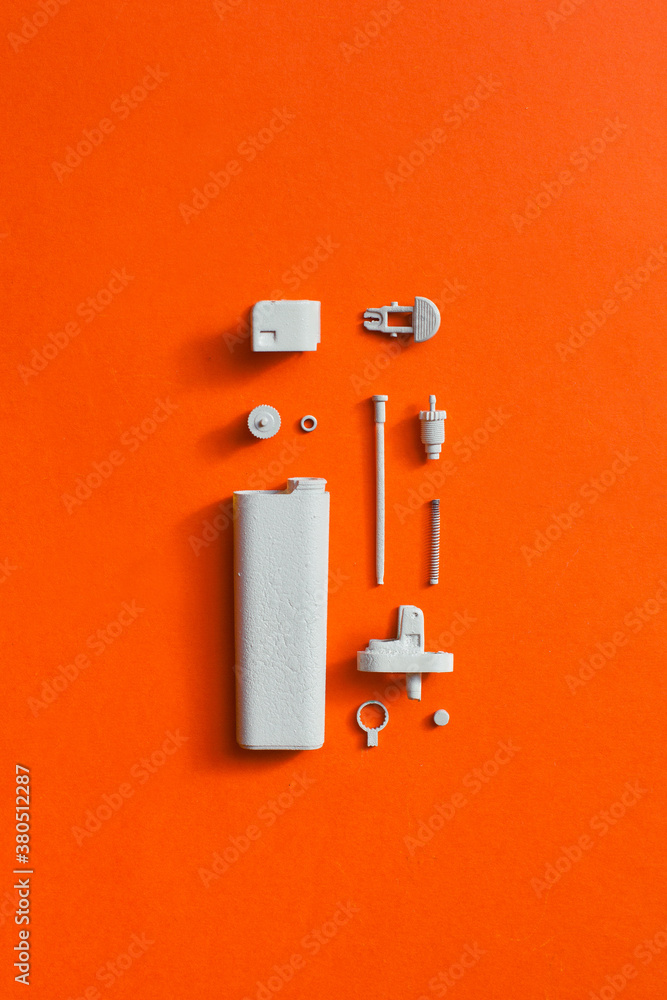 White disassembled lighter on orange/red background White disassembled lighter on orange/red background