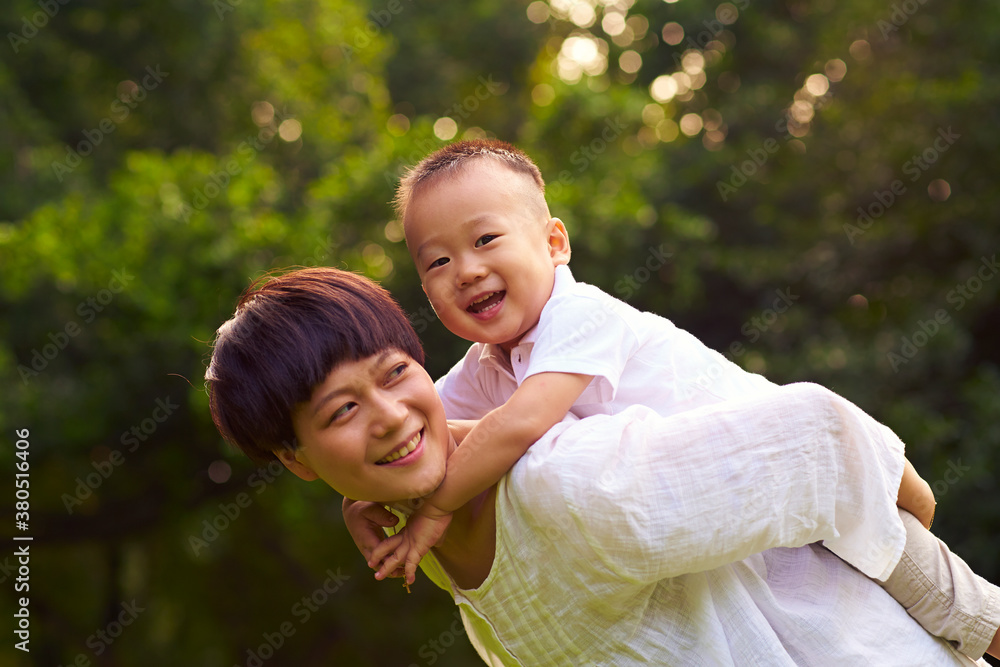 happy little asian boy with her mother outdoor in the summer park happy little asian boy with her mother outdoor in the summer park