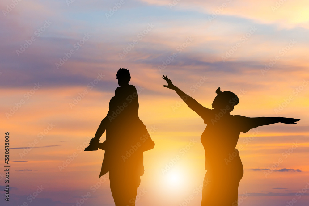 Silhouette of Happy father mother and daughter playing together outdoor, Cheerful family enjoying at sunset, Happiness family concepts
