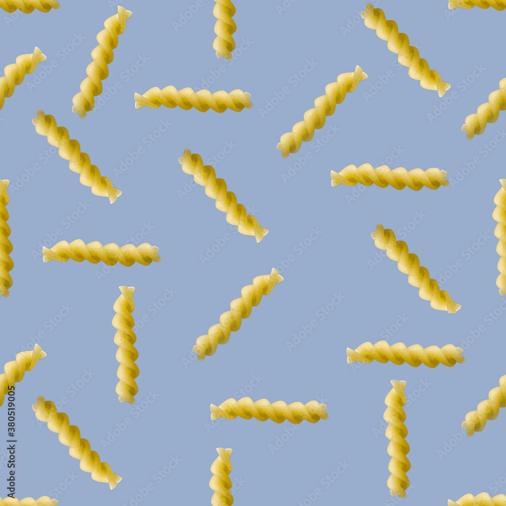 Obraz premium Fusilli pasta random flat lay on blue background without shadow. can be used as raw pasta background, poster, banner not pattern.