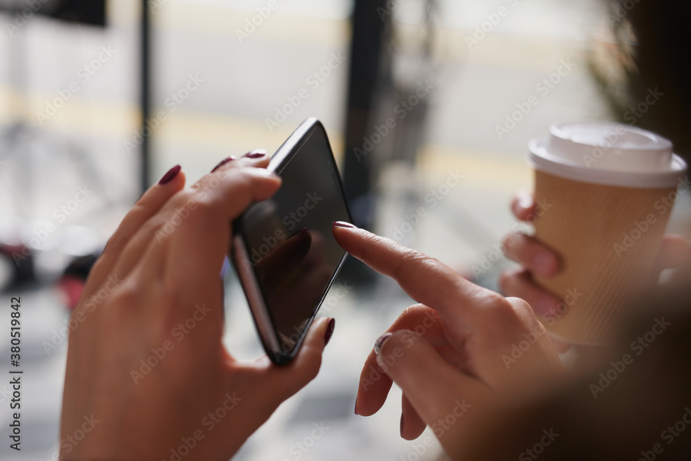 Young women pointing at smartphone using manicured hands Young women pointing at smartphone using manicured hands