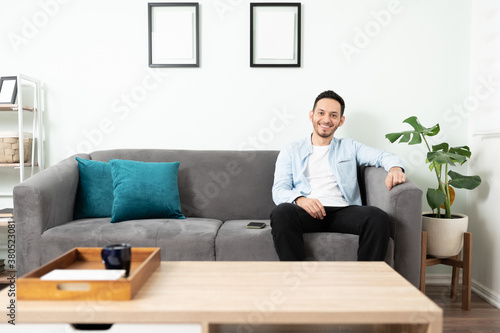 Man in his 30s sitting on a sofa