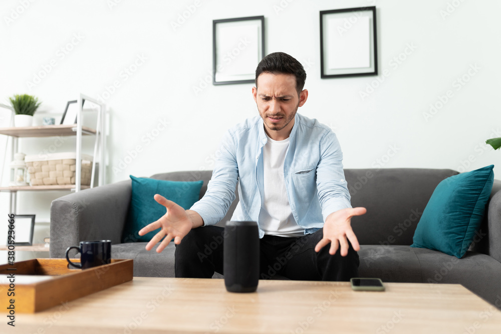 Man feeling stressed about his smart speaker Man feeling stressed about his smart speaker