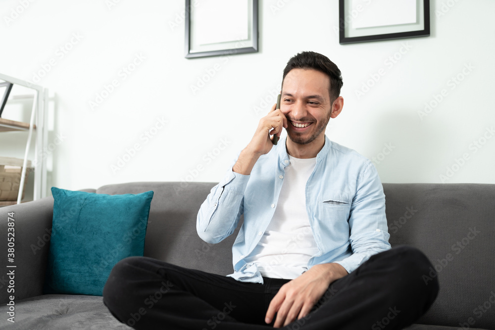 Hispanic man talking to a friend on the phone Hispanic man talking to a friend on the phone