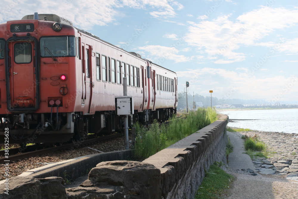 Obraz premium 海岸沿いを走るローカル電車と青空