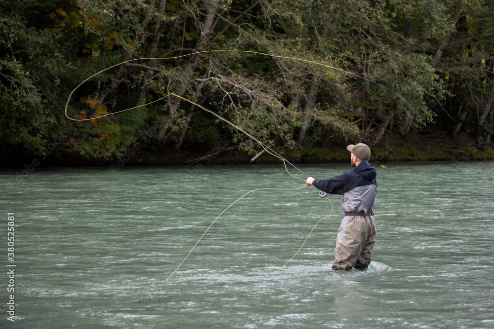 Squamish, British-Columbia / Canada - 09/23/2020: A Fly Fisherman casts his line for a fish on the Squamish River Squamish, British-Columbia / Canada - 09/23/2020: A Fly Fisherman casts his line for a fish on the Squamish River
