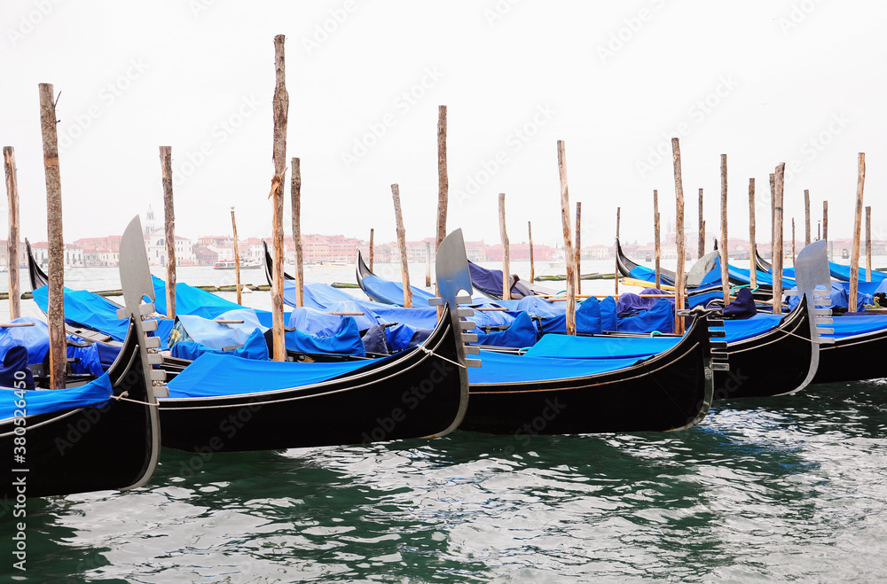 Gondolas moored docked on water in Venice.