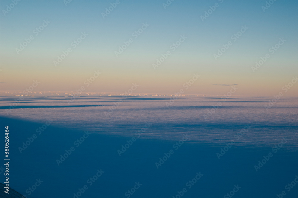 View of the polar plateau with icebergs and sea ice in the distance, Antarctica.