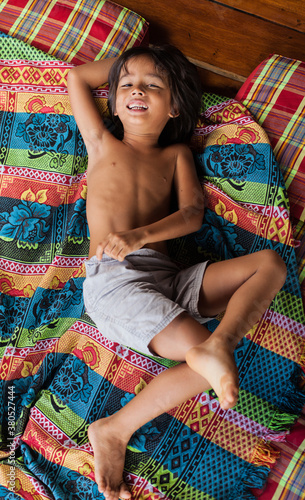 Cute little boy playing on colorful mattress. photo