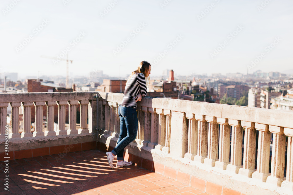 Young woman enjoying a sunny day on a rooftop. Young woman enjoying a sunny day on a rooftop.