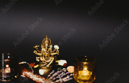 Table with occult attributes, top view. Ganesha figurine, stone rosaries, candles, aroma stick