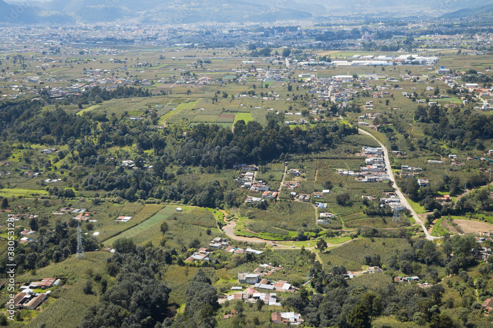 Rural villages surrounded by trees and crops seen from above - Aerial view of a part of a rural suburb in Quetzaltenango Guatemala
