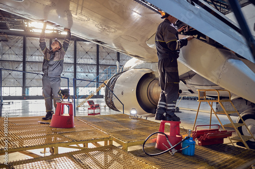 Engineer working on aircraft wing in aircraft maintenance factory photo