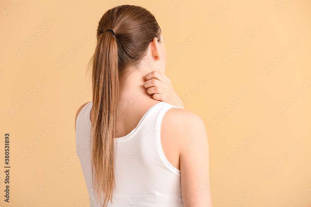 Young woman scratching her skin on color background Young woman scratching her skin on color background